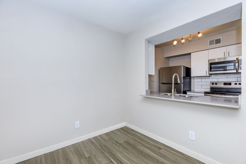 a kitchen with a large window and hardwood floors
