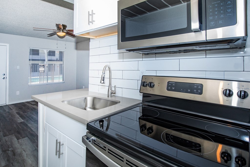 a kitchen with white cabinets and stainless steel appliances