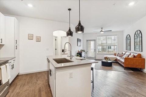 a kitchen with an island and a living room with a couch