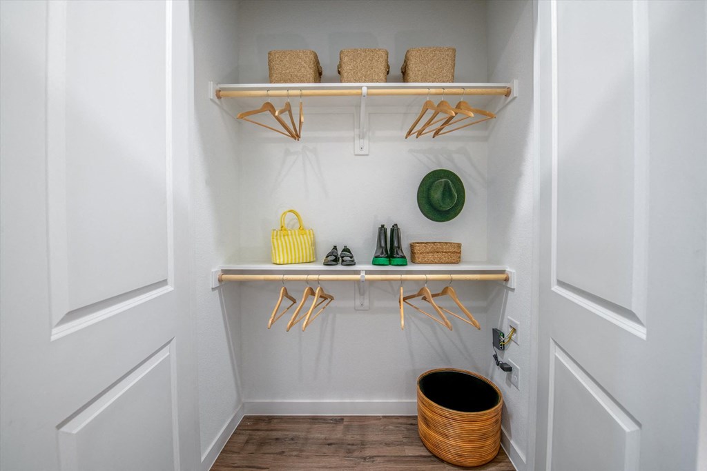 a small closet with shelves and hooks and a basket