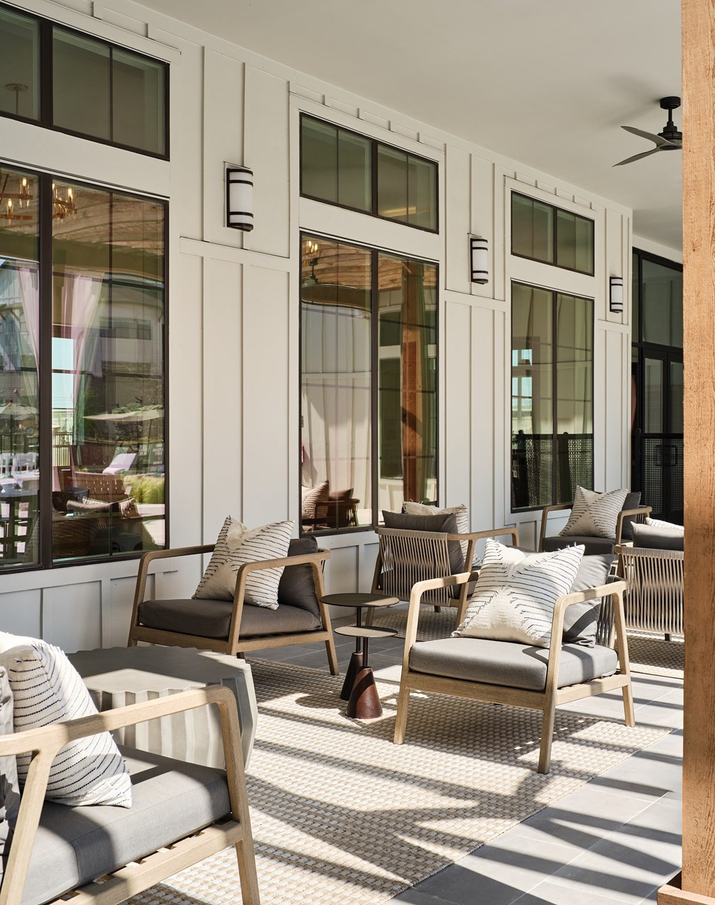 A patio with chairs and a ceiling fan.