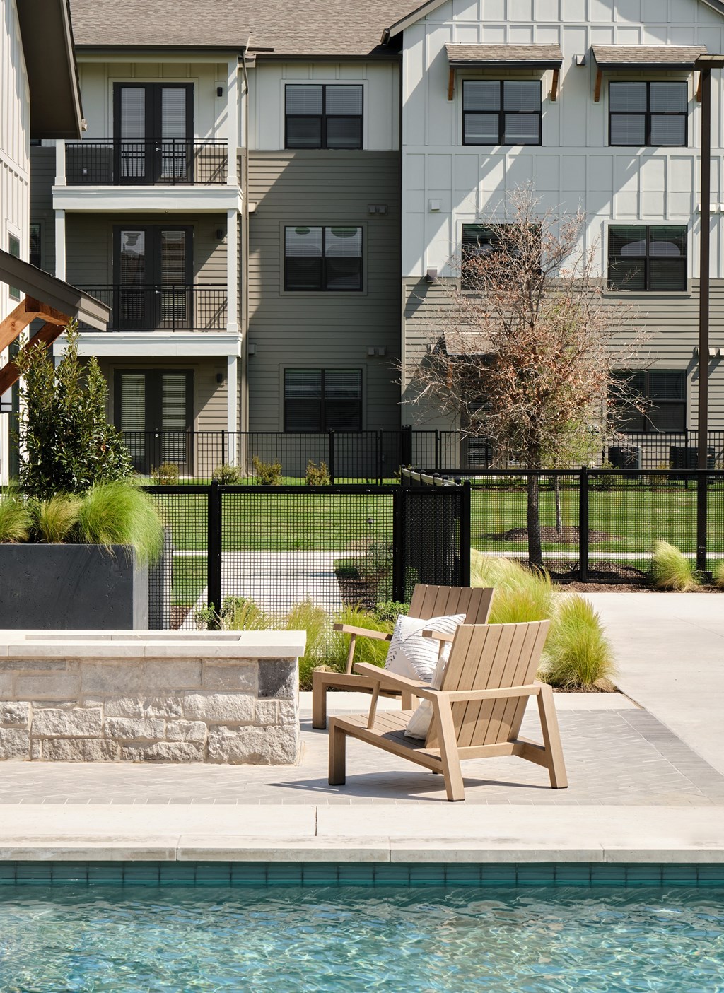 A chair sits by a pool in front of a building.