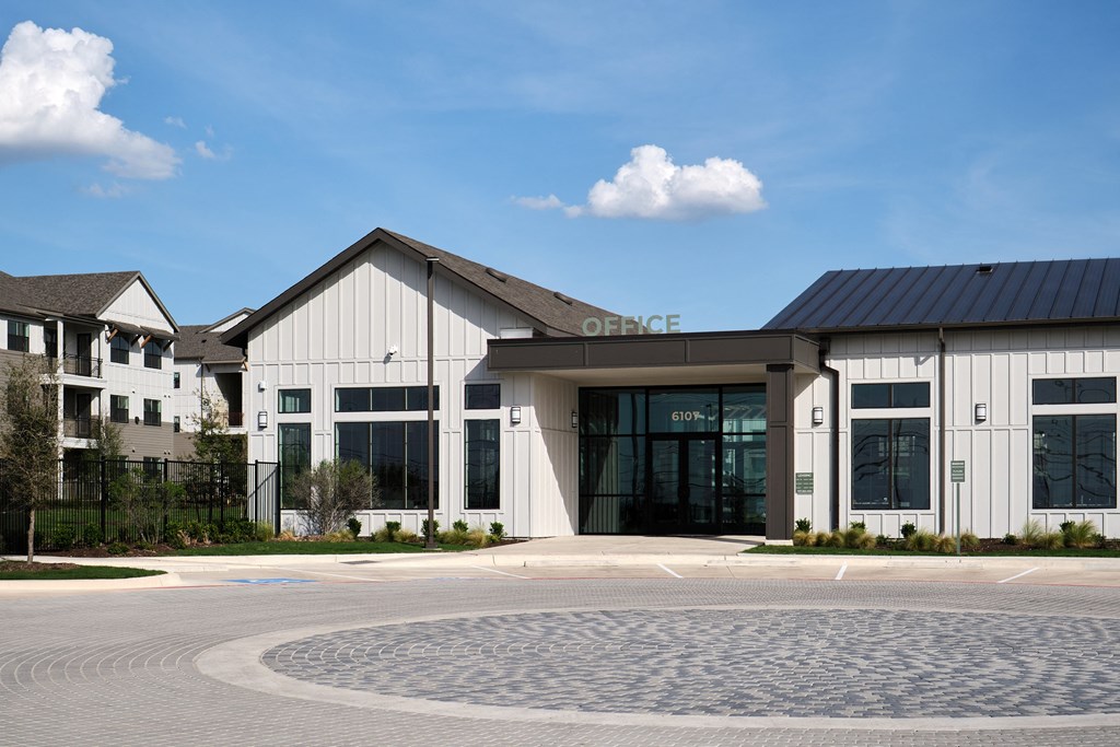 A modern building with a black roof and glass doors.