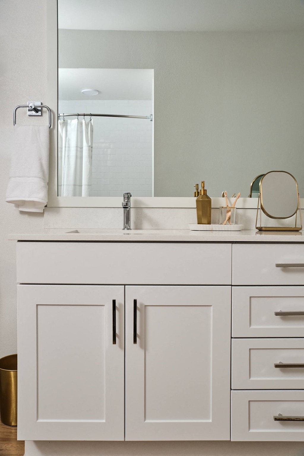 A white bathroom vanity with a mirror above it.