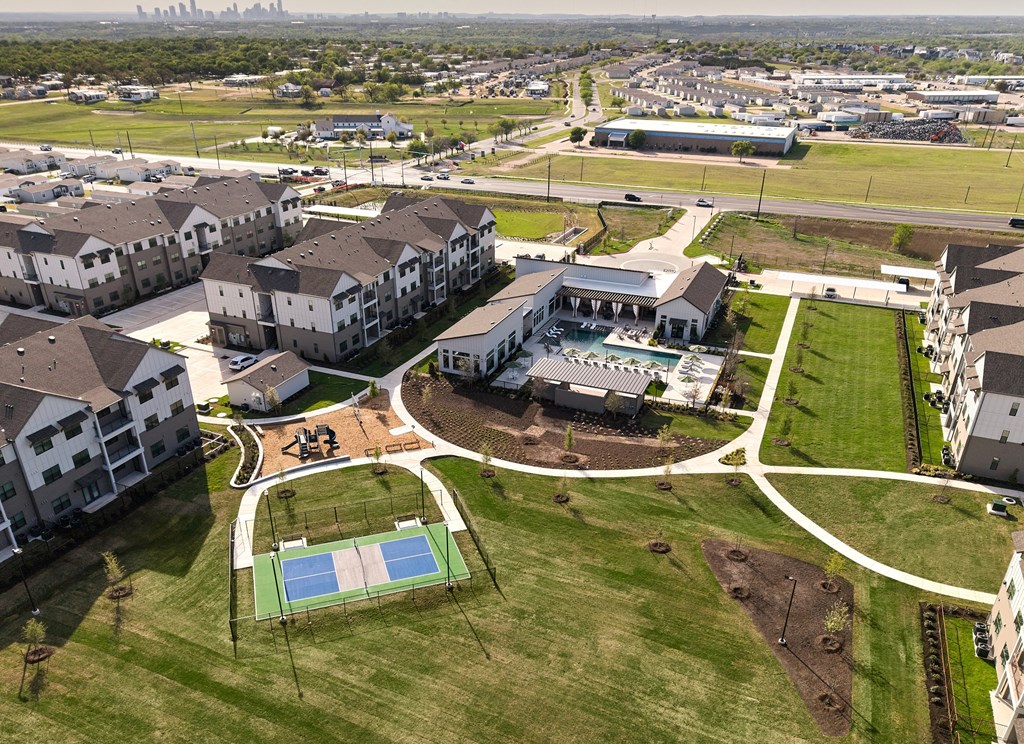 A large apartment complex with a swimming pool and tennis court.