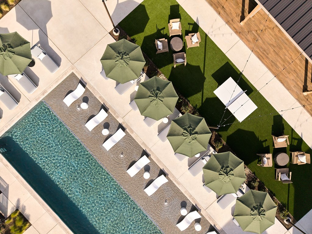 A pool surrounded by chairs and umbrellas.
