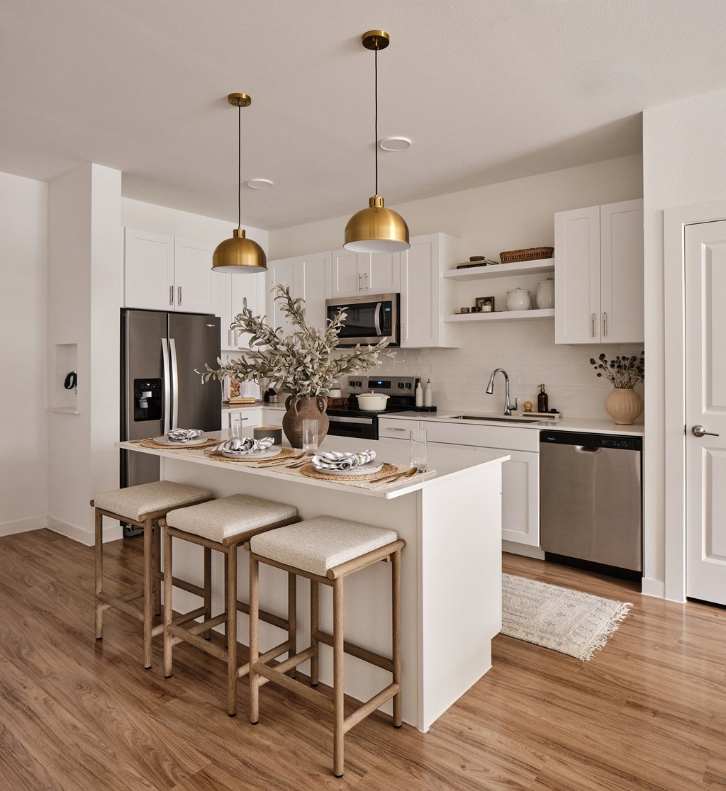 A kitchen with a white island and bar stools.