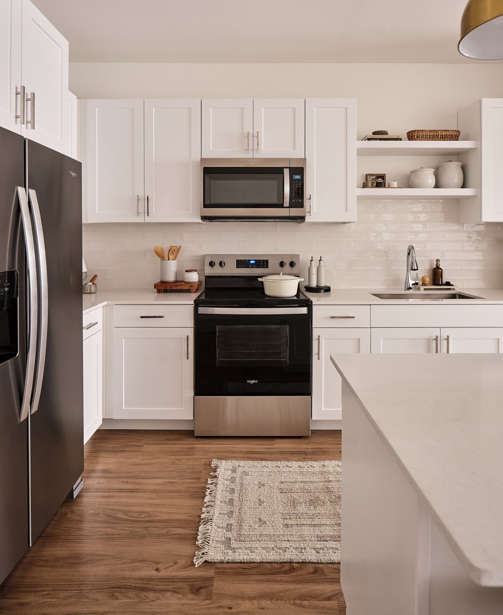 A modern kitchen with white cabinets and a black refrigerator.