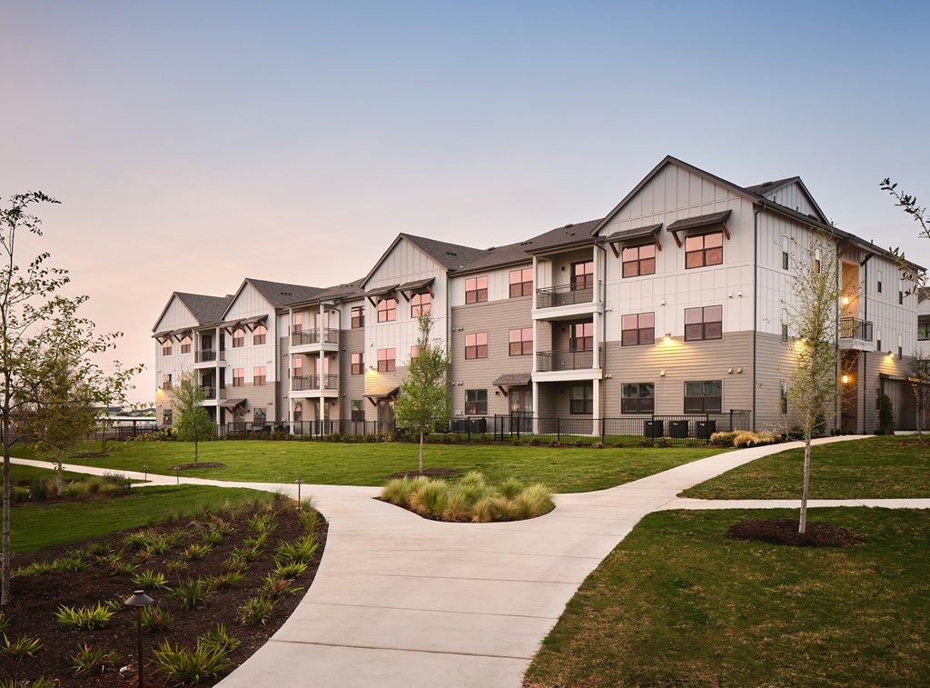 A modern apartment complex with a walkway in front.