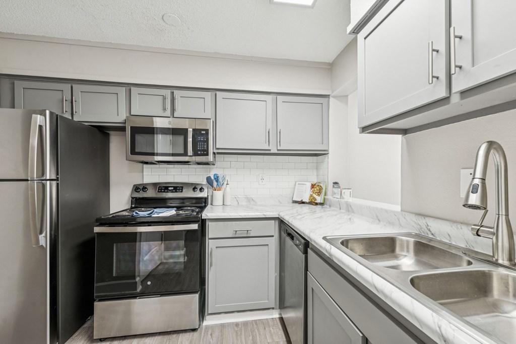 A modern kitchen with stainless steel appliances and white cabinets.