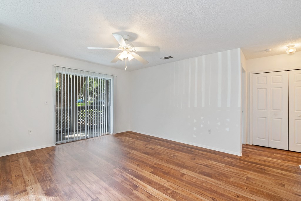 A room with wooden floors and a ceiling fan.