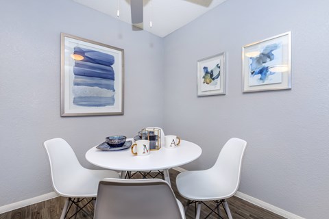 A white table with two chairs and a bowl on it.