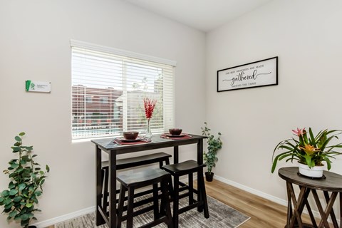 A dining room with a table and chairs.