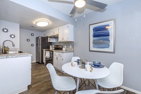A kitchen with a table and chairs in the middle of the room.