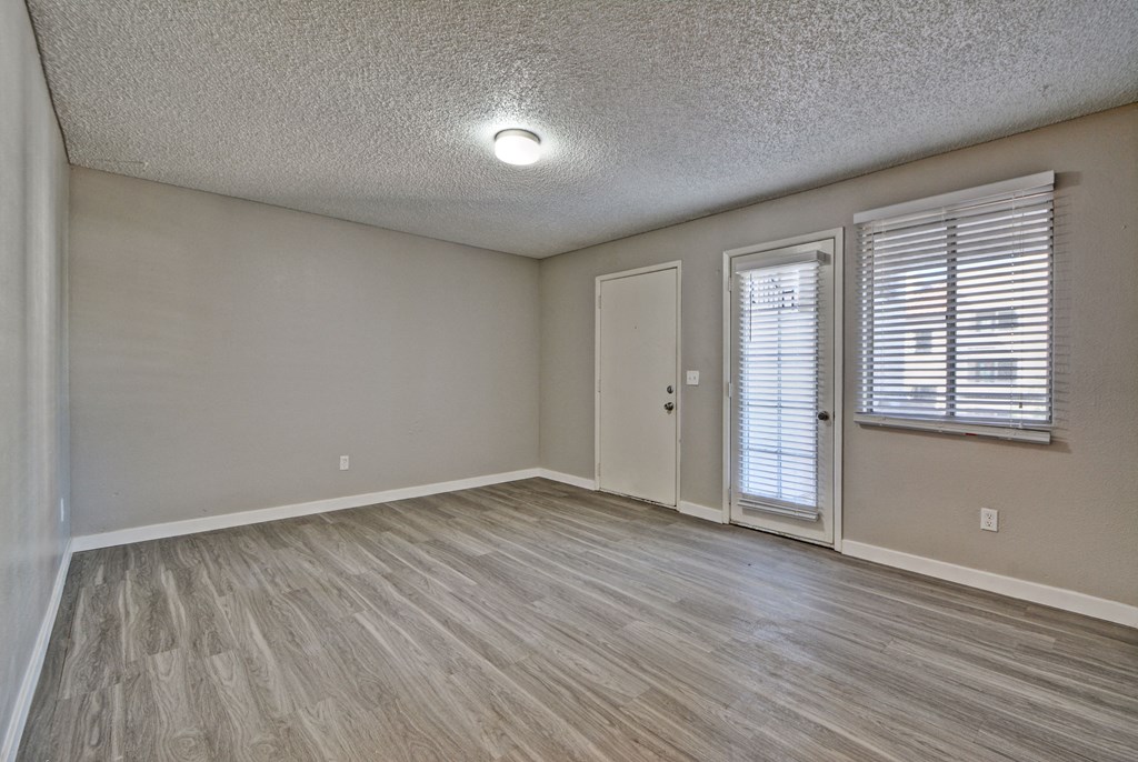 a bedroom with hardwood floors and a door to a balcony
