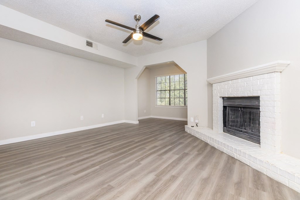 a living room with a fireplace and a ceiling fan