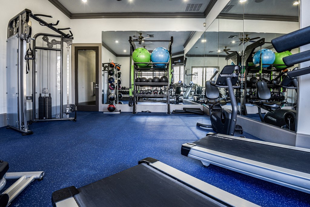 a gym with cardio machines and weights on the floor