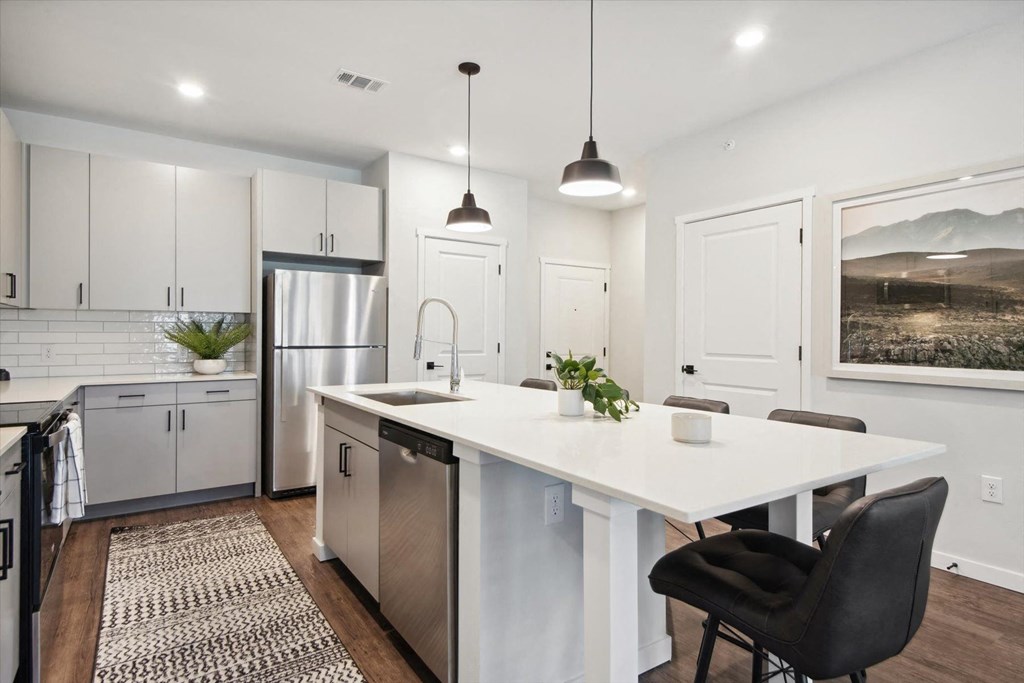 an open kitchen with white cabinets and a white counter top