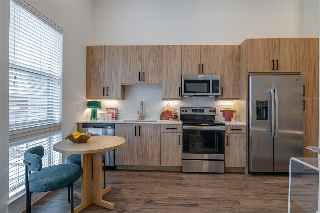 a kitchen with stainless steel appliances and a small table