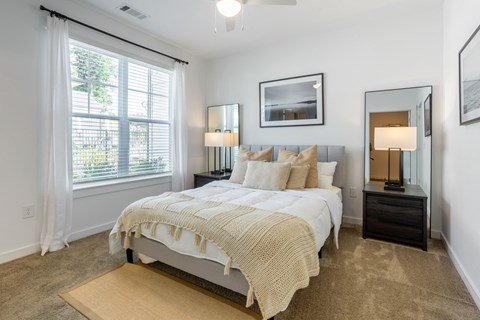 a bedroom with a bed and a large window