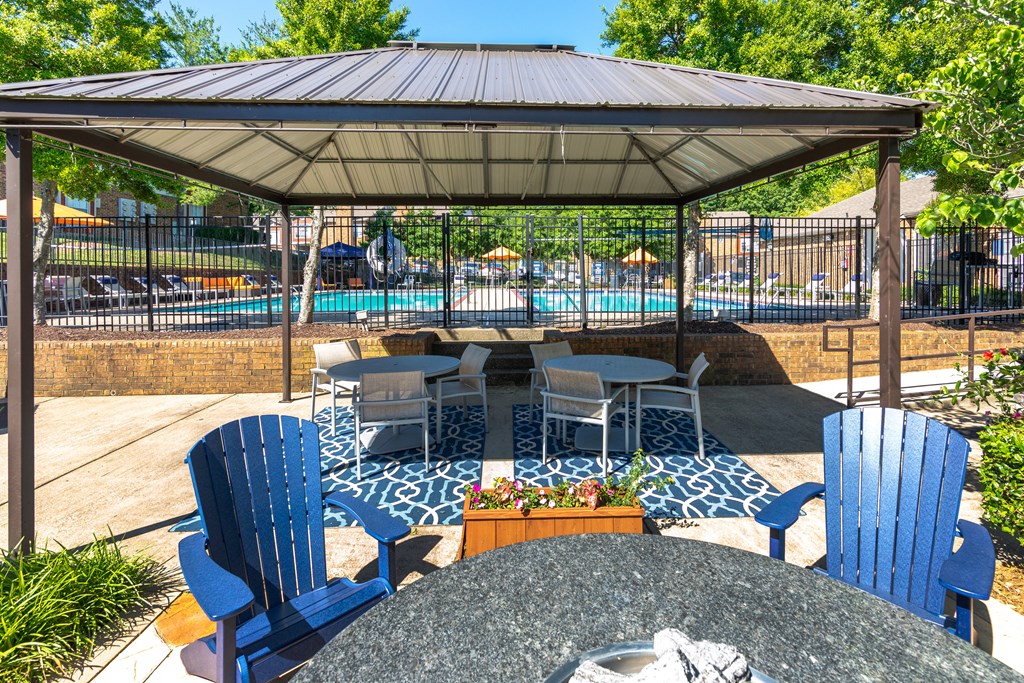 a patio with a table and chairs and a gazebo