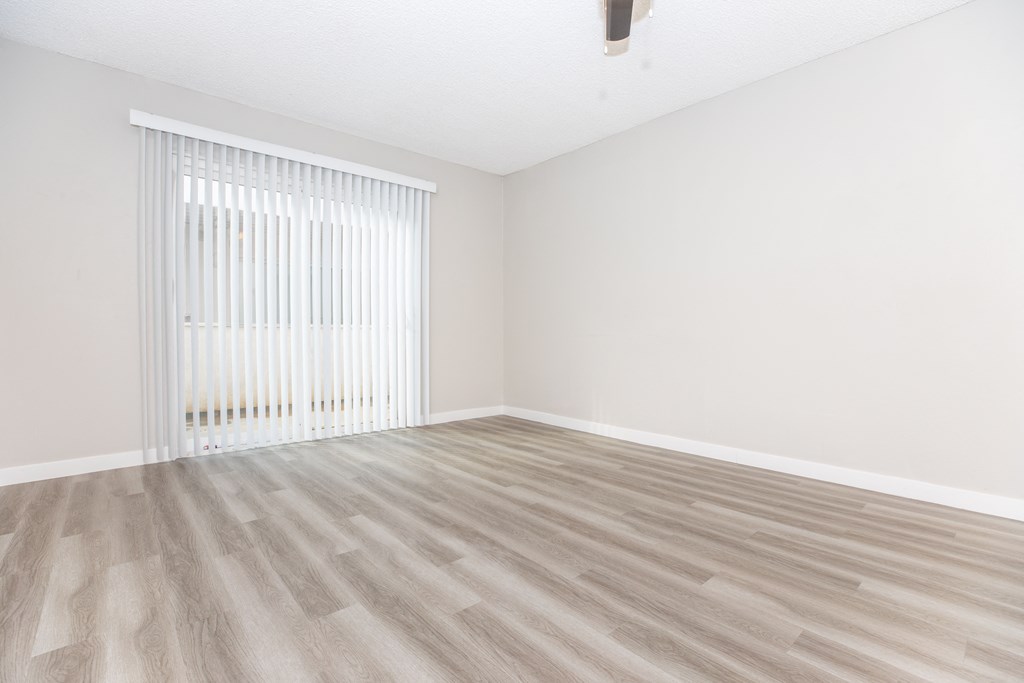 a bedroom with a hardwood floor and white walls