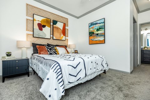 a bedroom with a bed and paintings on the wall