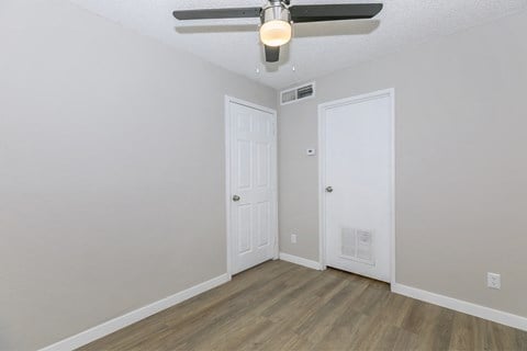 a bedroom with a ceiling fan and a door to a closet