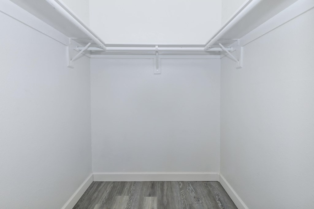 an empty room with white walls and a wood floor