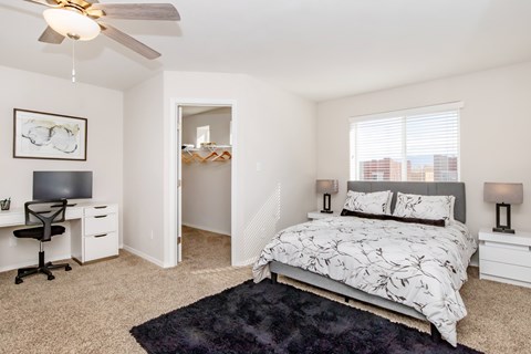 A bedroom with a bed, desk, and chair.