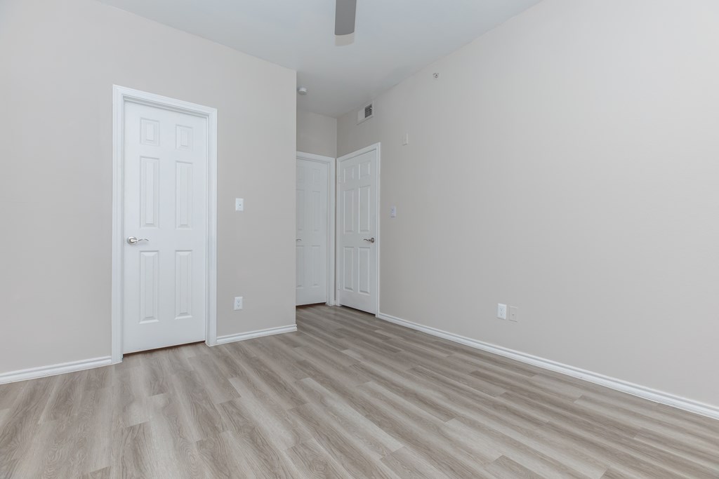 a bedroom with hardwood floors and grey walls