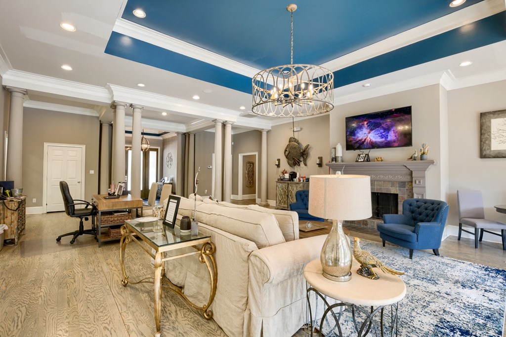 a living room with a blue ceiling and white furniture