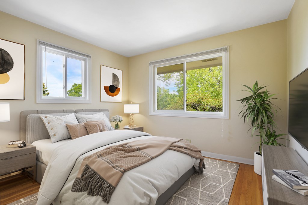 a bedroom with a bed and two windows