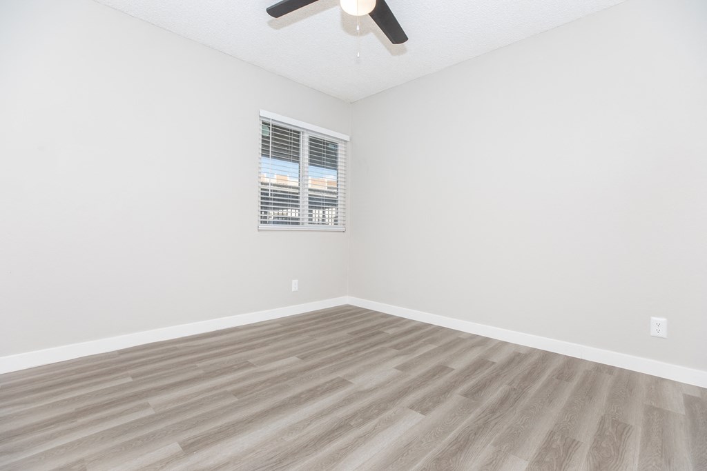 a bedroom with a ceiling fan and hardwood floors