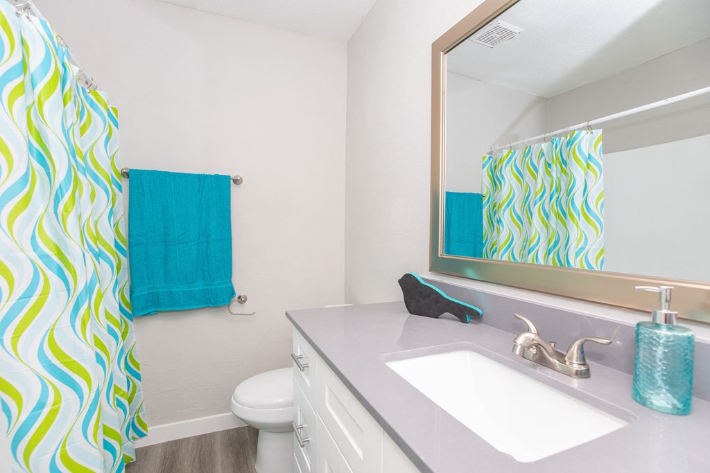 a bathroom with a white sink and a blue shower curtain