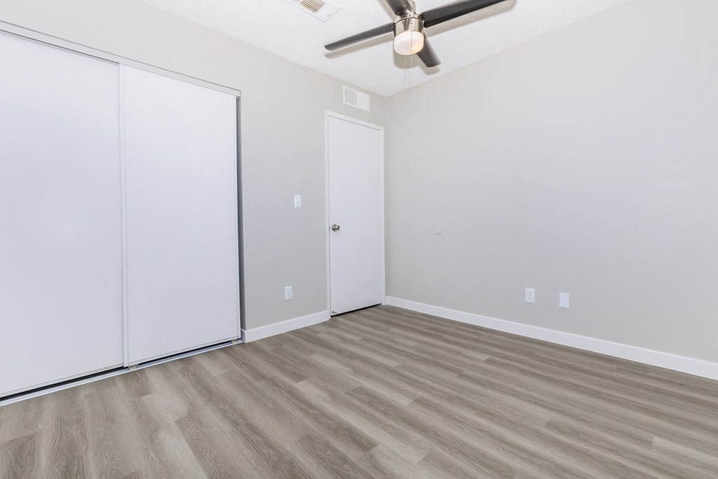 an empty room with white walls and a ceiling fan
