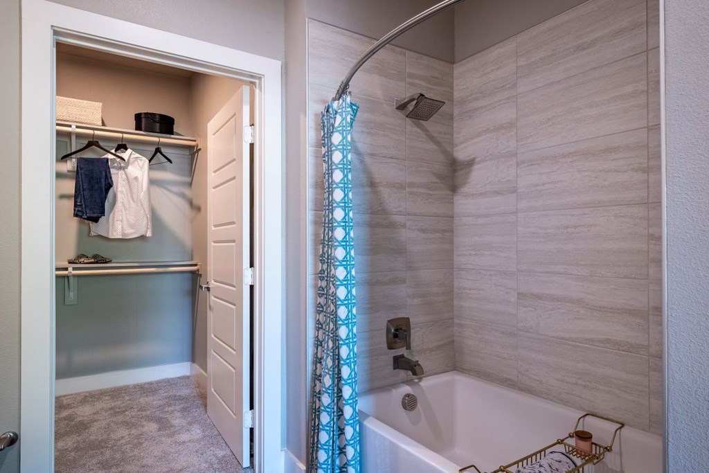 A bathroom with a white tub and a shower curtain.