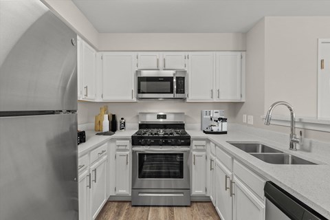 a kitchen with stainless steel appliances and white cabinets