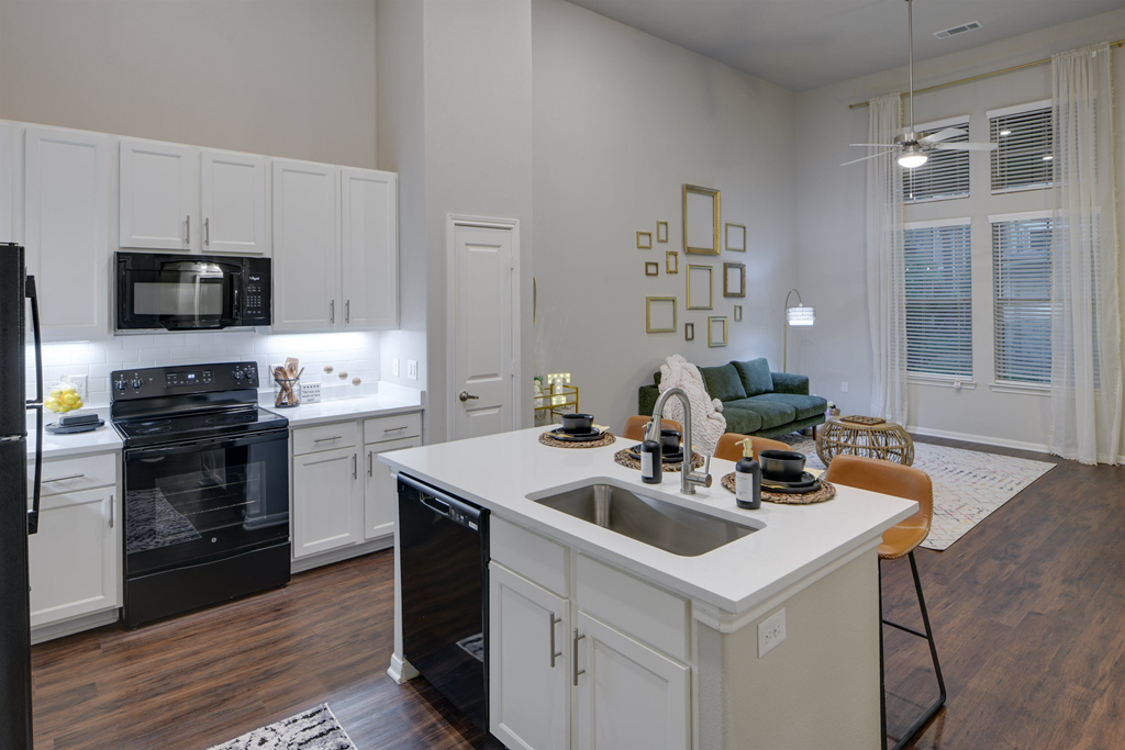 an open kitchen and living room with a sink and a counter top