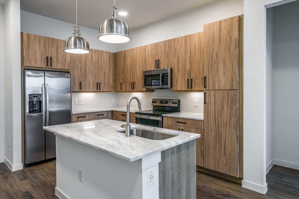 a kitchen with stainless steel appliances and a marble counter top