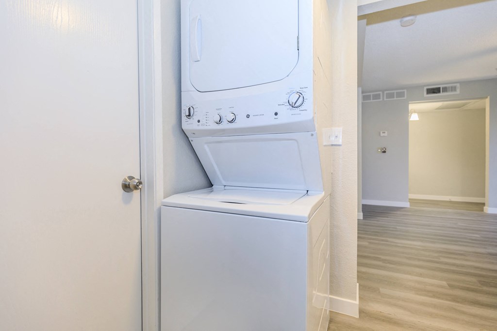 a white washer and dryer in a room with a hallway and a door