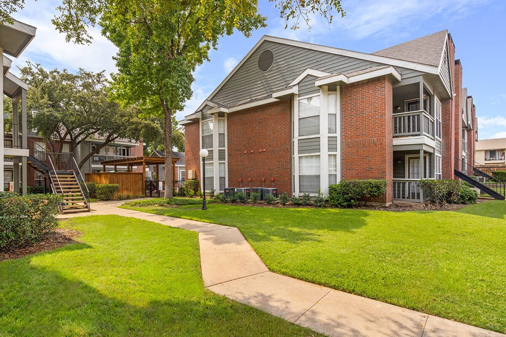 A brick building with a green lawn in front.