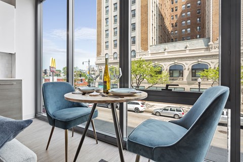 a dining room with a table and chairs in front of a window
