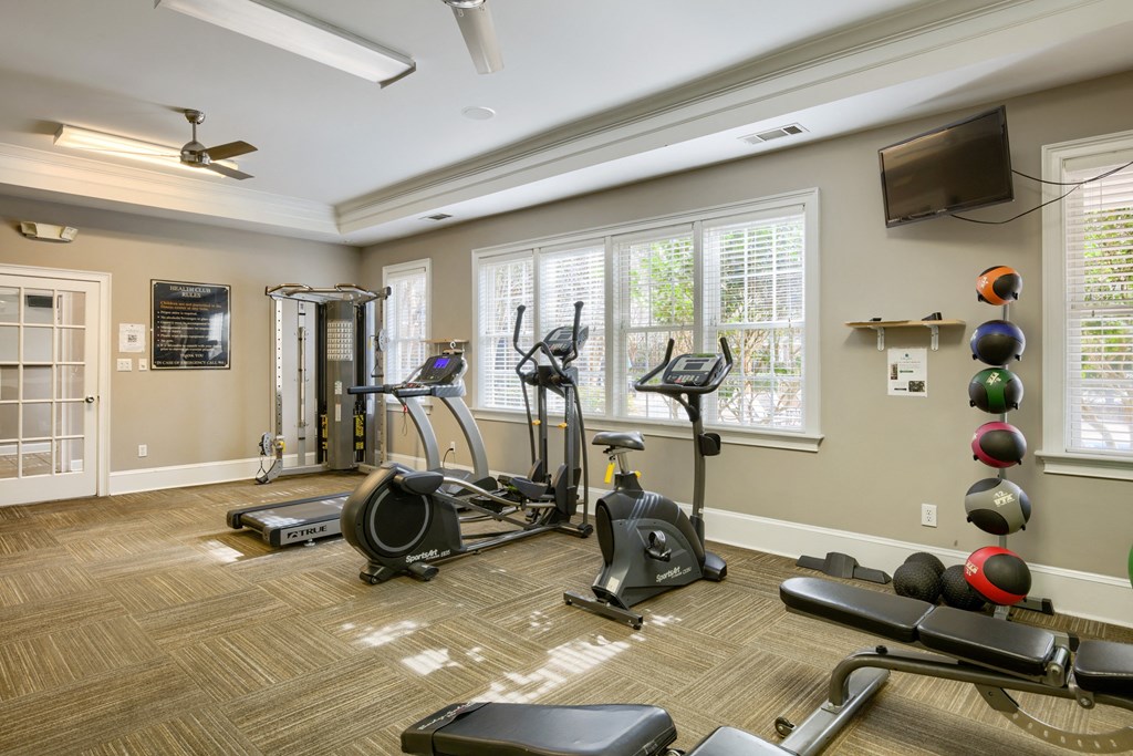gym with exercise equipment and windows at the district flats apartments in lenexa