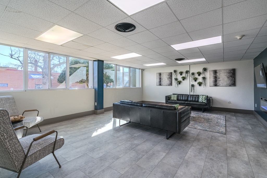 a lobby with a couch and chairs and a television