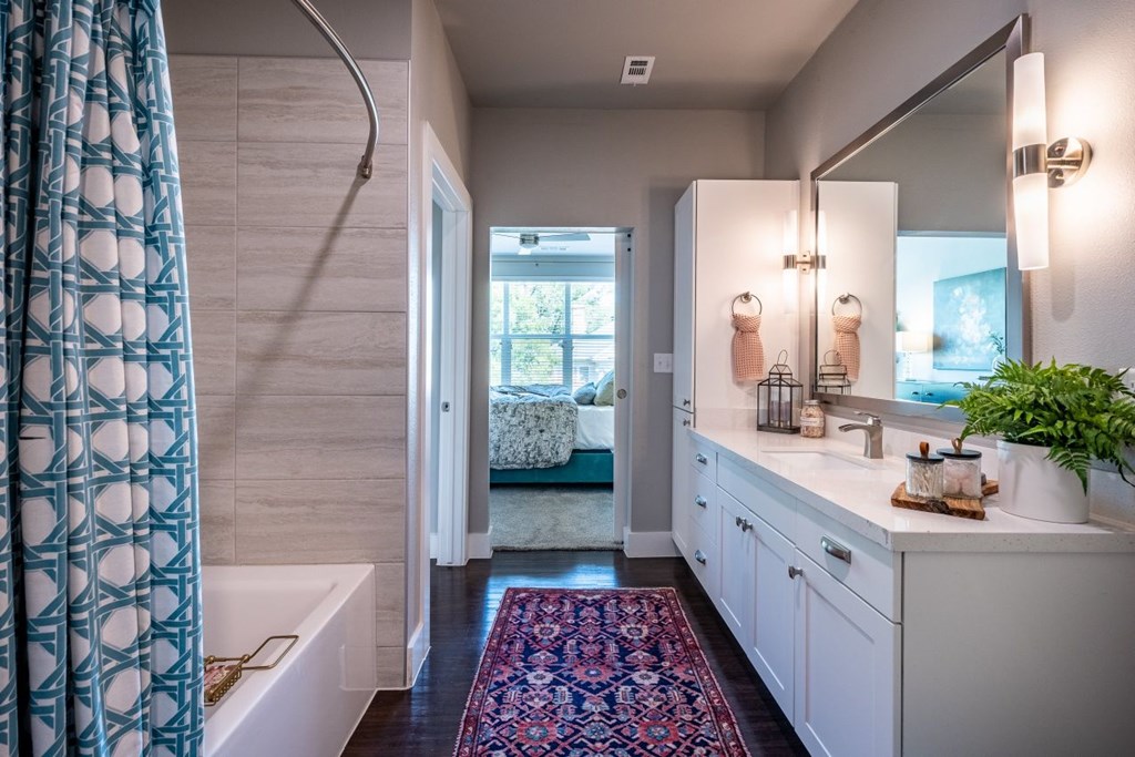 A bathroom with a white tub and a white sink.