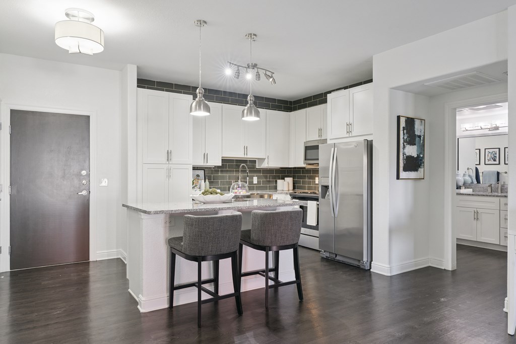A kitchen with a table and chairs in the middle.
