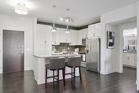 A kitchen with a table and chairs in the middle.