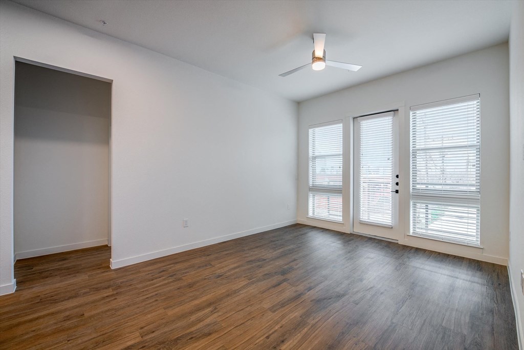an empty living room with wood floors and white walls