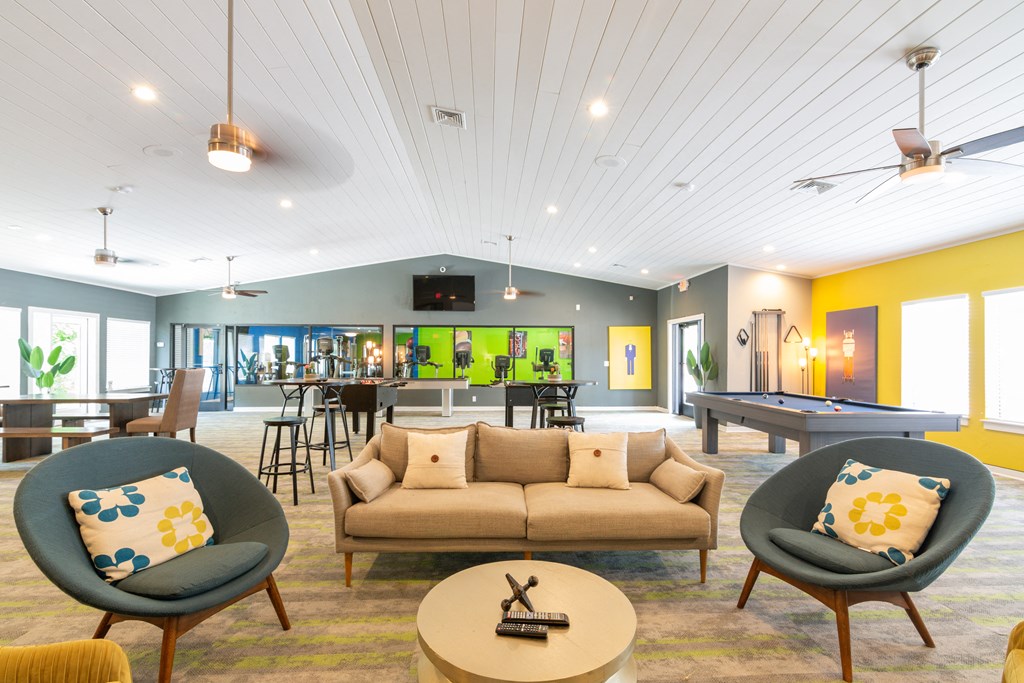 a living room filled with furniture and a pool table